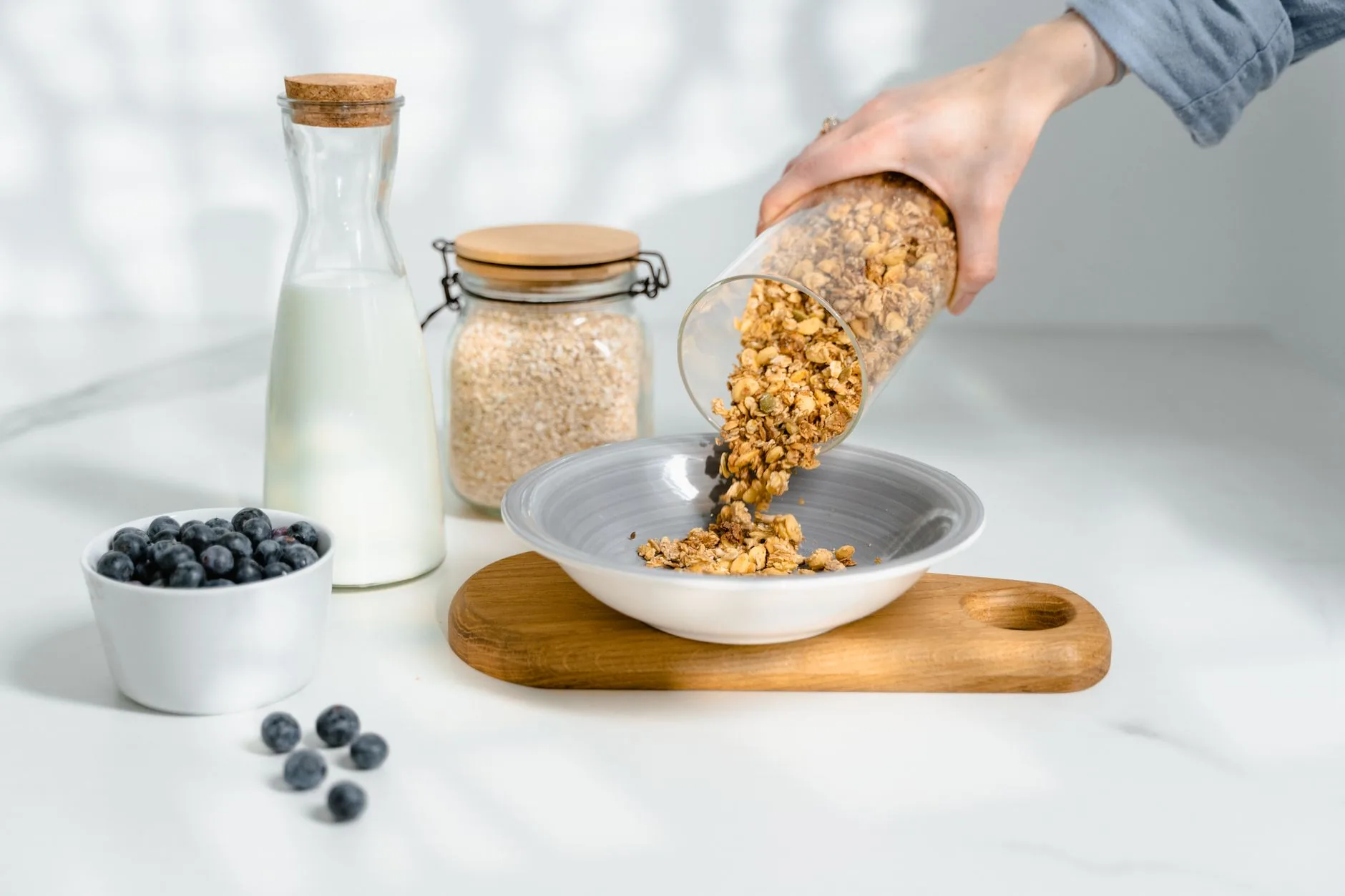 Bircher muesli with apple on rustic wooden table in sunlit kitchen.