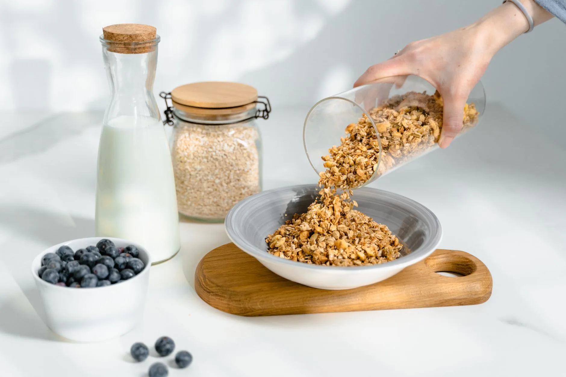 A sunlit kitchen counter with muesli ingredients. Bircher muesli recipe overnight.